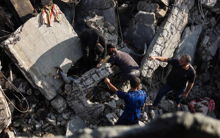 فلسطينيون يبحثون عن جثة تحت أنقاض منزل دمرته غارات الاحتلال على مدينة غزة | وكالة الأنباء الفرنسية