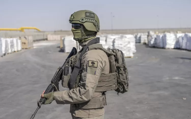 جندي من جيش الاحتلال بجانب طرود مساعدات عند معبر كرم أبو سالم في قطاع غزة | وكالة الأنباء الألمانية