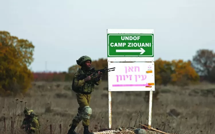 جنديان من جيش الاحتلال الإسرائيلي بجانب إشارة في موقع تابع لمراقبي الأمم المتحدة قرب معبر القنيطرة في الجولان | الوكالة الأوروبية للصور الصحفية