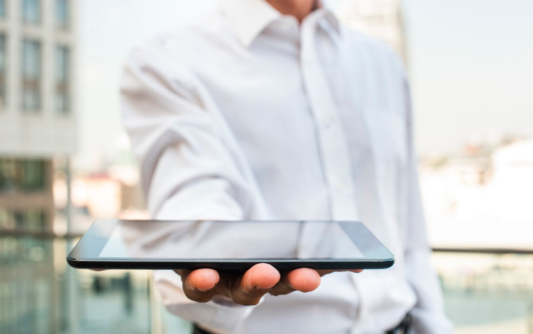 رجل يحمل جهازا لوحيا | تعبيرية freepik