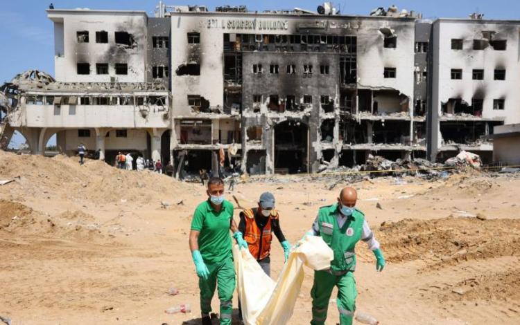 كوادر طبية تنقل جثامين من ساحة مجمع الشفاء الطبي