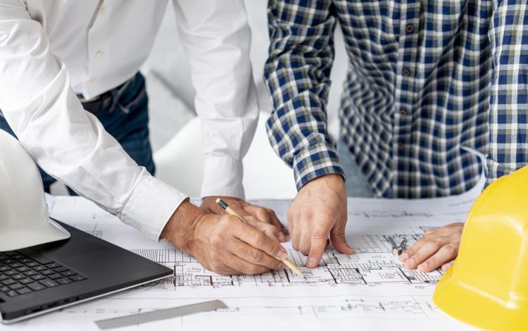 مهندسان يطلعان على مخططات موقع | تعبيرية Freepik