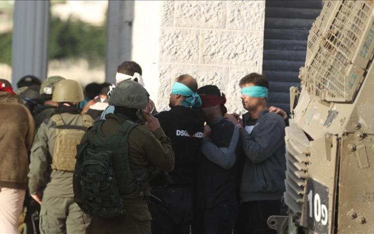 جنود الاحتلال يعصبون أعين فلسطينيين أثناء اعتقالهم بوقت سابق في الضفة الغربية | الأناضول