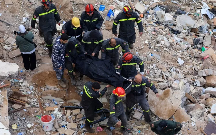 فرق الدفاع المدني اللبنانية يحملون جثمان أحد ضحايا انهيار عقار في طرابلس 8/2/2026 | رويترز