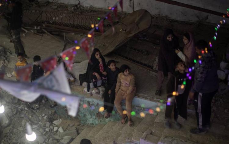 فلسطينيون يعلقون الزينة فوق أنقاض منازلهم المدمرة في خانيونس جنوبي قطاع غزة استعدادا لاستقبال شهر رمضان المبارك | وكالة الأنباء الفرنسية