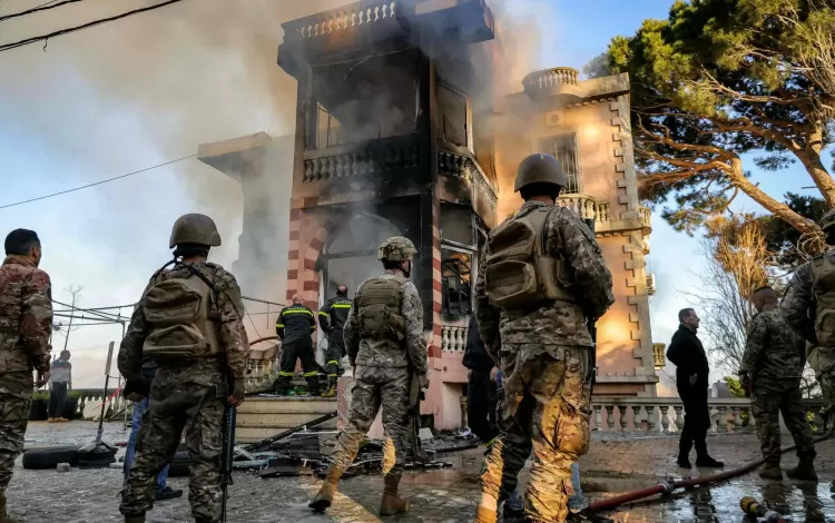 جنود لبنانيون وعناصر من الدفاع المدني يتفقدون مبنى احترق إثر قصف إسرائيلي على قرية مرجعيون جنوب لبنان | وكالة الأنباء الفرنسية