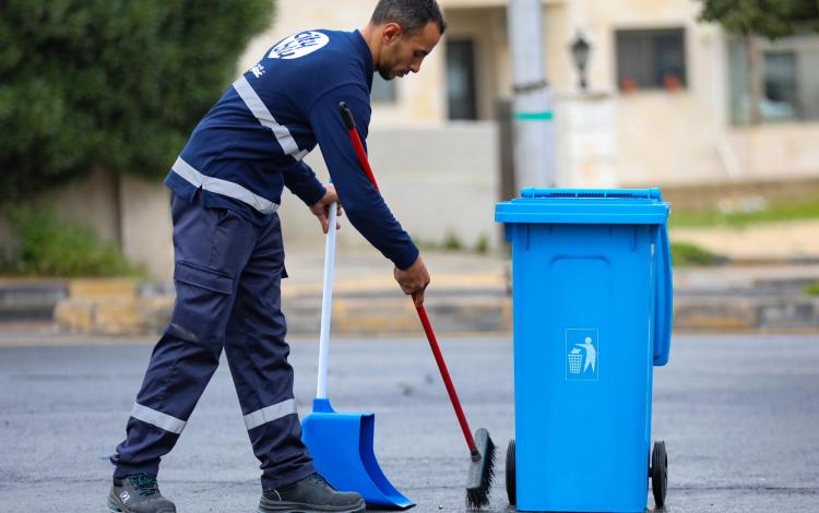 أحد كوادر أمانة عمان خلال حملة جمع ونقل النفايات في منطقتي زهران وطارق | أمانة عمان