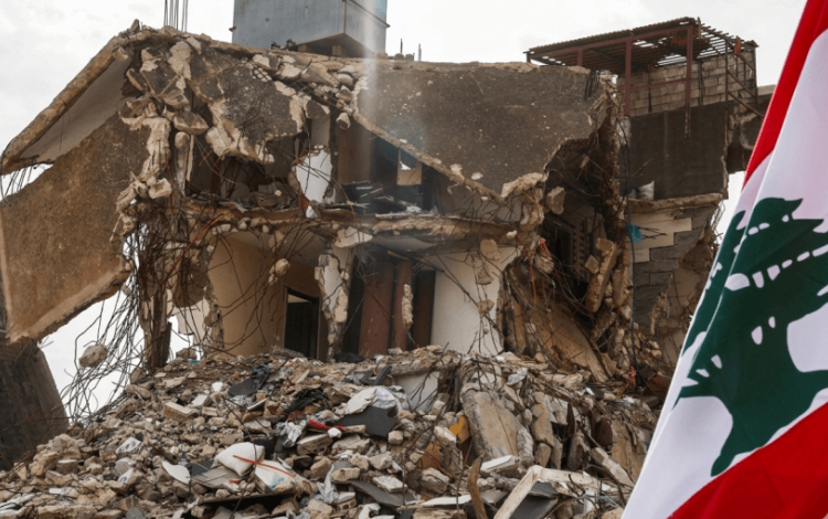 علم لبنان بجوار مبنى دمرته غارة إسرائيلية في قرية كفر كلا جنوب لبنان | رويترز