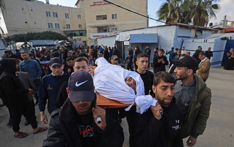 مشيعون يحملون جثمان فلسطيني استشهد إثر غارة إسرائيلية على دير البلح | وكالة الأنباء الفرنسية