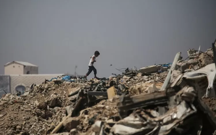 صبي فلسطيني يمشي وسط الأنقاض قرب مخيم للنازحين في منطقة النصيرات وسط غزة 28/6/2026 | وكالة الأنباء الفرنسية
