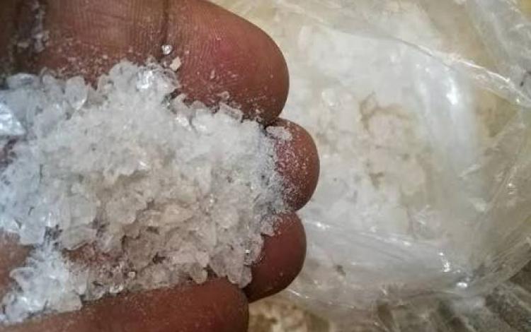شخص يعرض بيده كمية من مادة الكريستال المخدرة