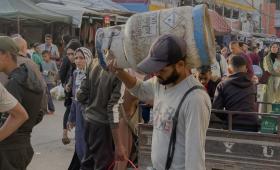 فلسطيني يحمل على كتفه أسطوانة غاز | وكالة الأنباء الفرنسية