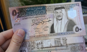 شخص يمسك بعملة أردنية من فئة 50 دينار