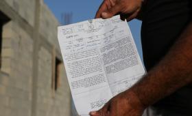 فلسطيني يستعرض إخطارا بهدم منزله تسلمه من قوات الاحتلال في وقت سابق بالضفة الغربية | وفا