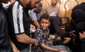 طفل فلسطيني بجوار جثمان شقيقه الذي استشهد بغارة إسرائيلية في خانيونس جنوب غزة 24/6/2026 | وكالة الأنباء الفرنسية