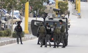 عدد من جنود الاحتلال يقتادون شابا فلسطينيا لاعتقاله | الأناضول