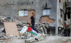 شاب بجانبه العلم الفلسطيني فوق أنقاض مبنى مدمر في جباليا شمالي قطاع غزة 24/10/2025 |شينخوا
