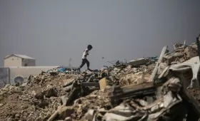صبي فلسطيني يمشي وسط الأنقاض قرب مخيم للنازحين في منطقة النصيرات وسط غزة 28/6/2026 | وكالة الأنباء الفرنسية